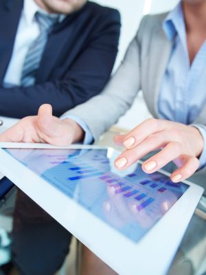 Reviewing results Human hands during discussion of business document in touchscreen at meeting