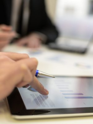 Business team using tablet computer to work with financial data Close-up of a modern business team using tablet computer to work with financial data